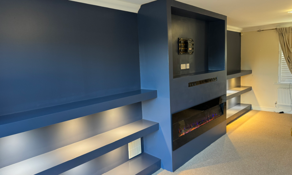 An executive media wall installation with shelving and TV unit and fireplace